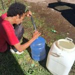 Pessoas buscam água em bica na periferia de Porto Alegre